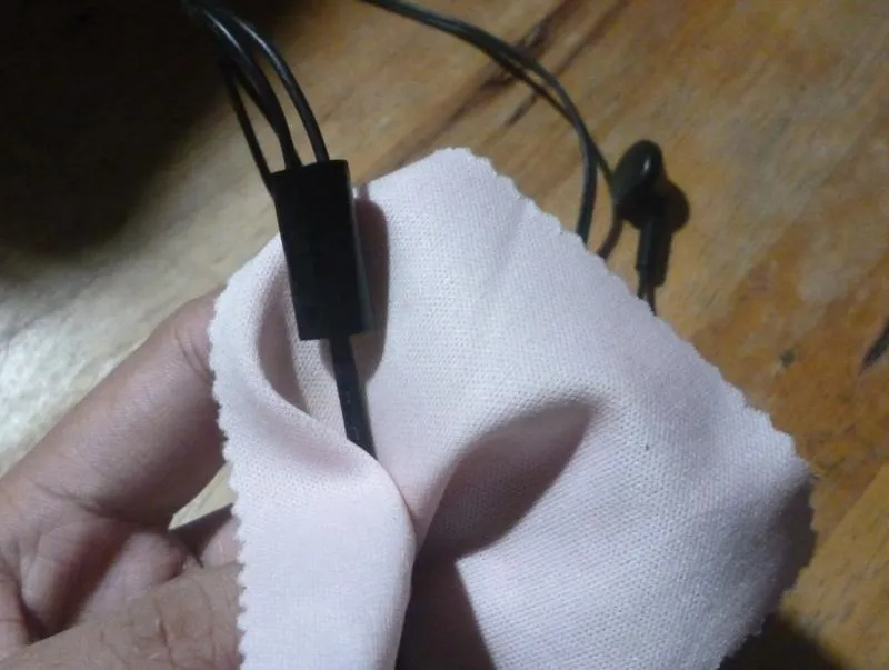 Limpando o cabo do fone de ouvido com pano rosa