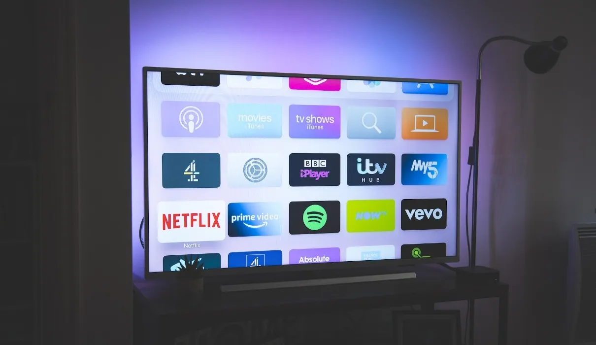 Großer eingeschalteter 4K-Fernseher mit Symbolen für Streaming-Apps