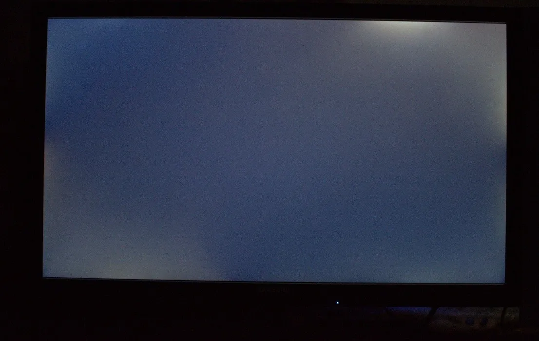 Téléviseur grand écran montrant l'effet de saignement du rétroéclairage dans une pièce sombre