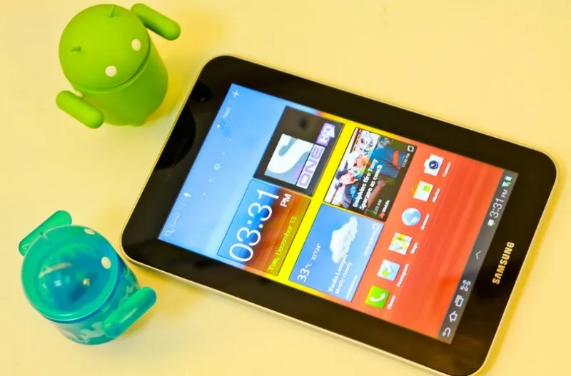 Um tablet Samsung com dois mascotes Android.