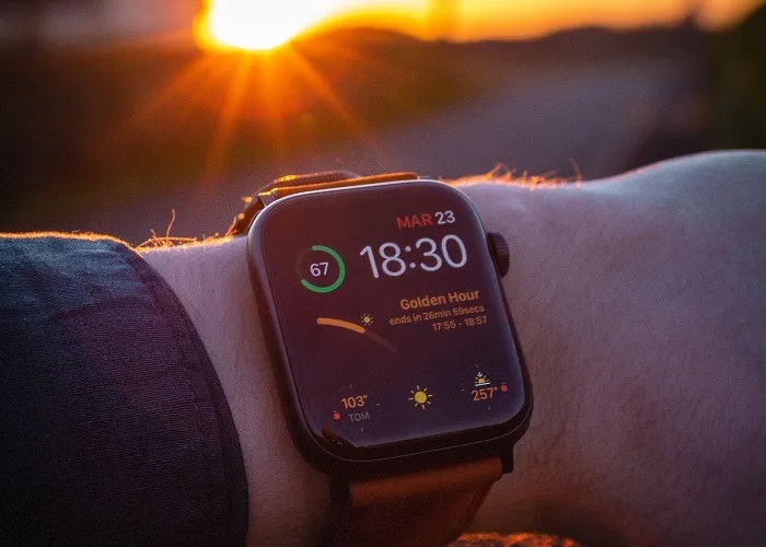 Uomo che indossa Apple Watch al tramonto.