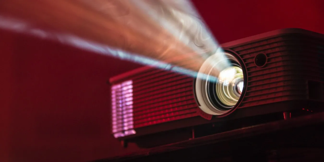 Een foto van een projector die voor een rode achtergrond draait.