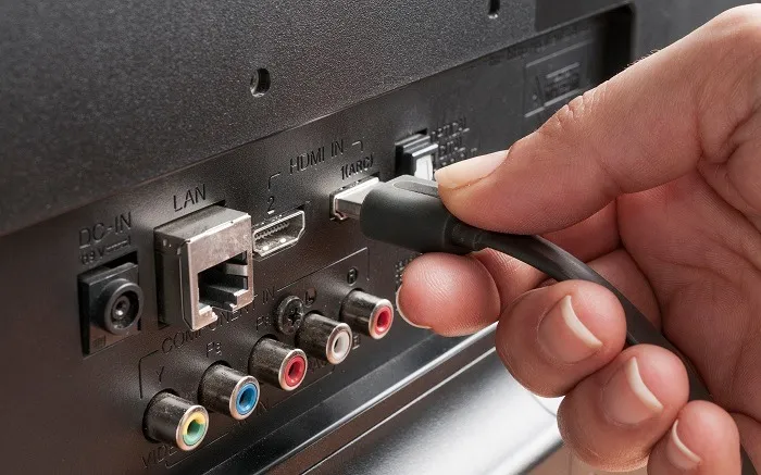 Retrait et réinsertion du câble HDMI de son port sur un téléviseur.