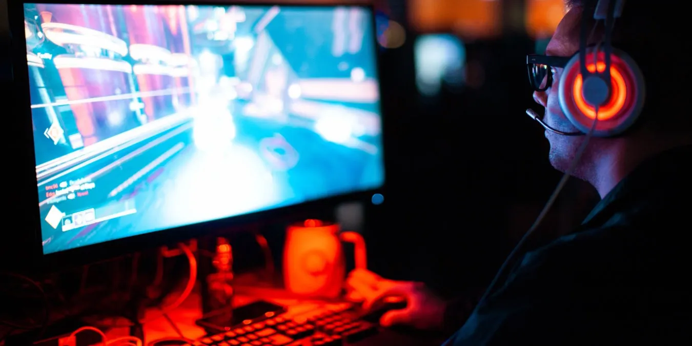 デスクトップ PC でビデオ ゲームをプレイしている人の写真。