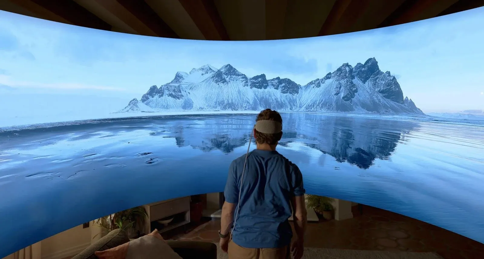 Person, die in das 180-Grad-Panoramabild einiger Eisberge läuft. Sie befinden sich in der Bildmitte und tragen ein Apple Vision Pro-Headset.