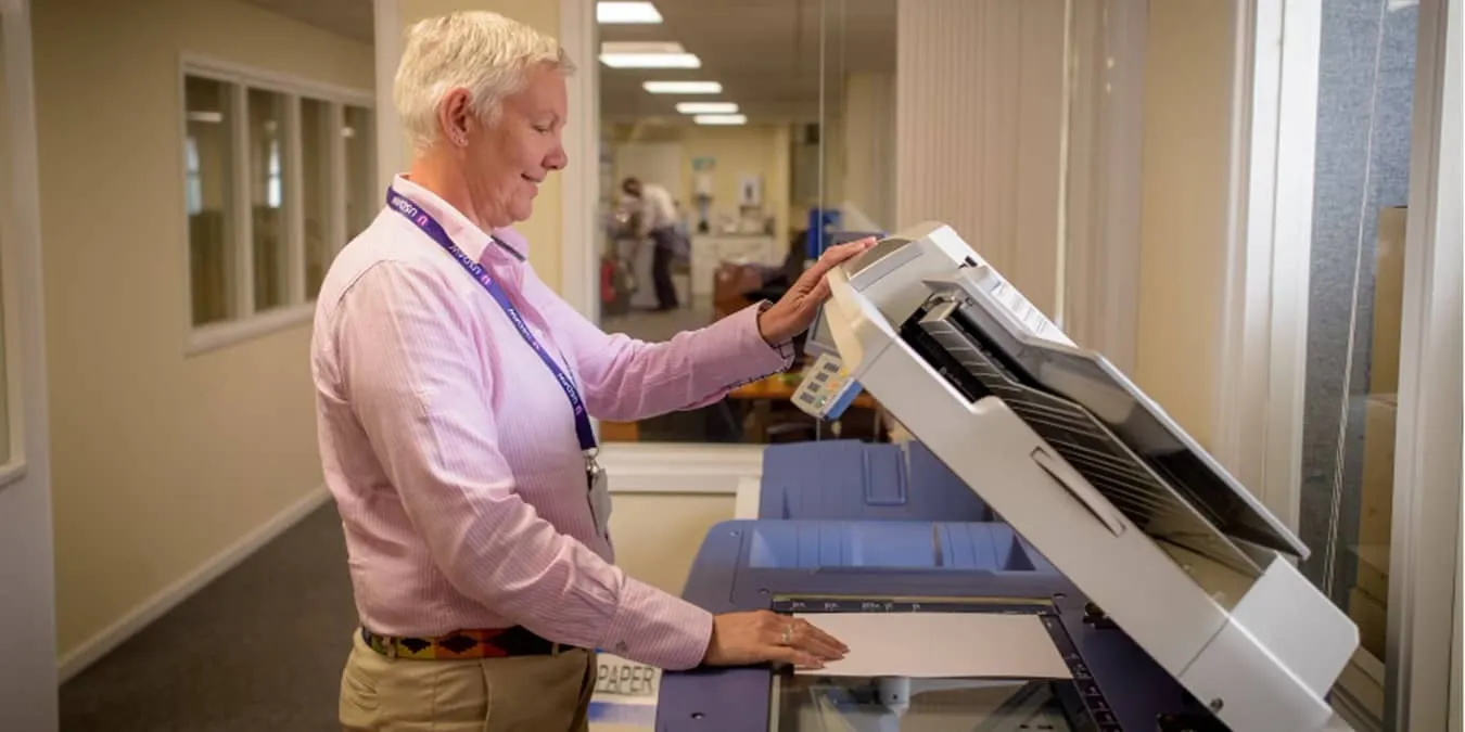 Homme utilisant un grand scanner copieur.