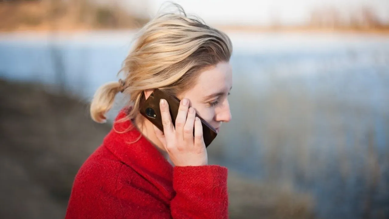 Una mujer afuera hablando por su teléfono.