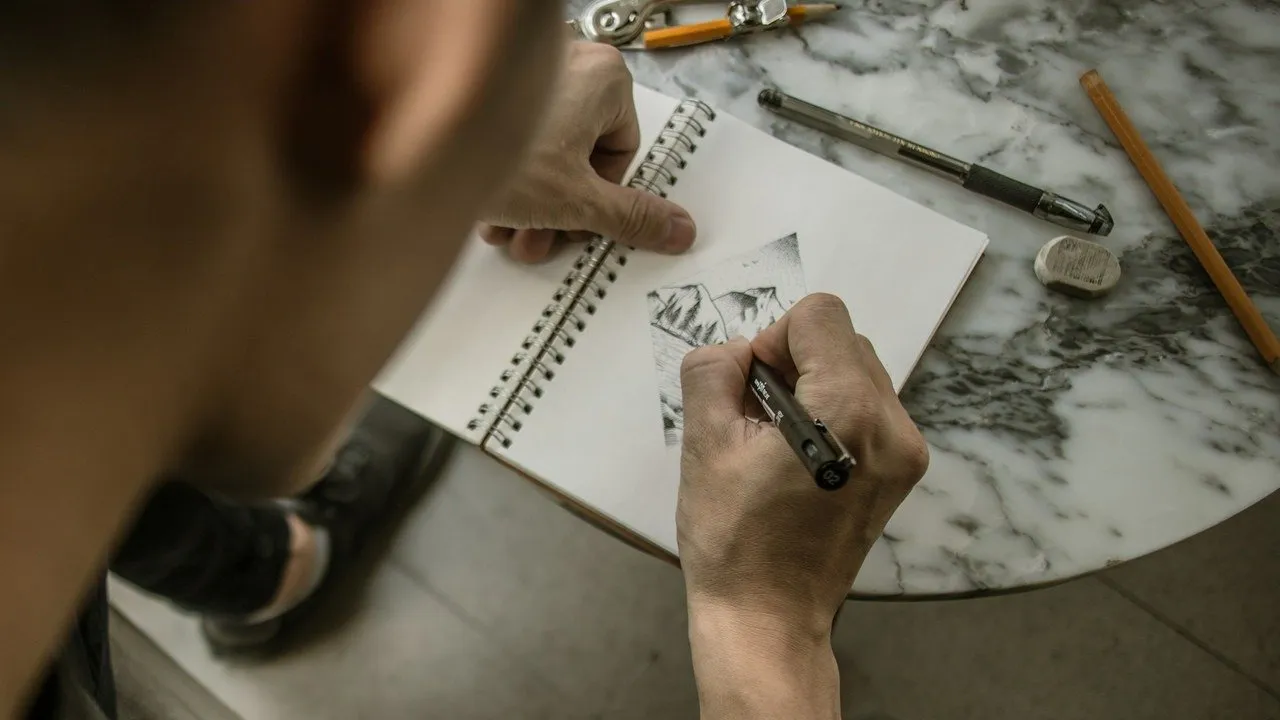 Persona dibujando en un cuaderno de bocetos