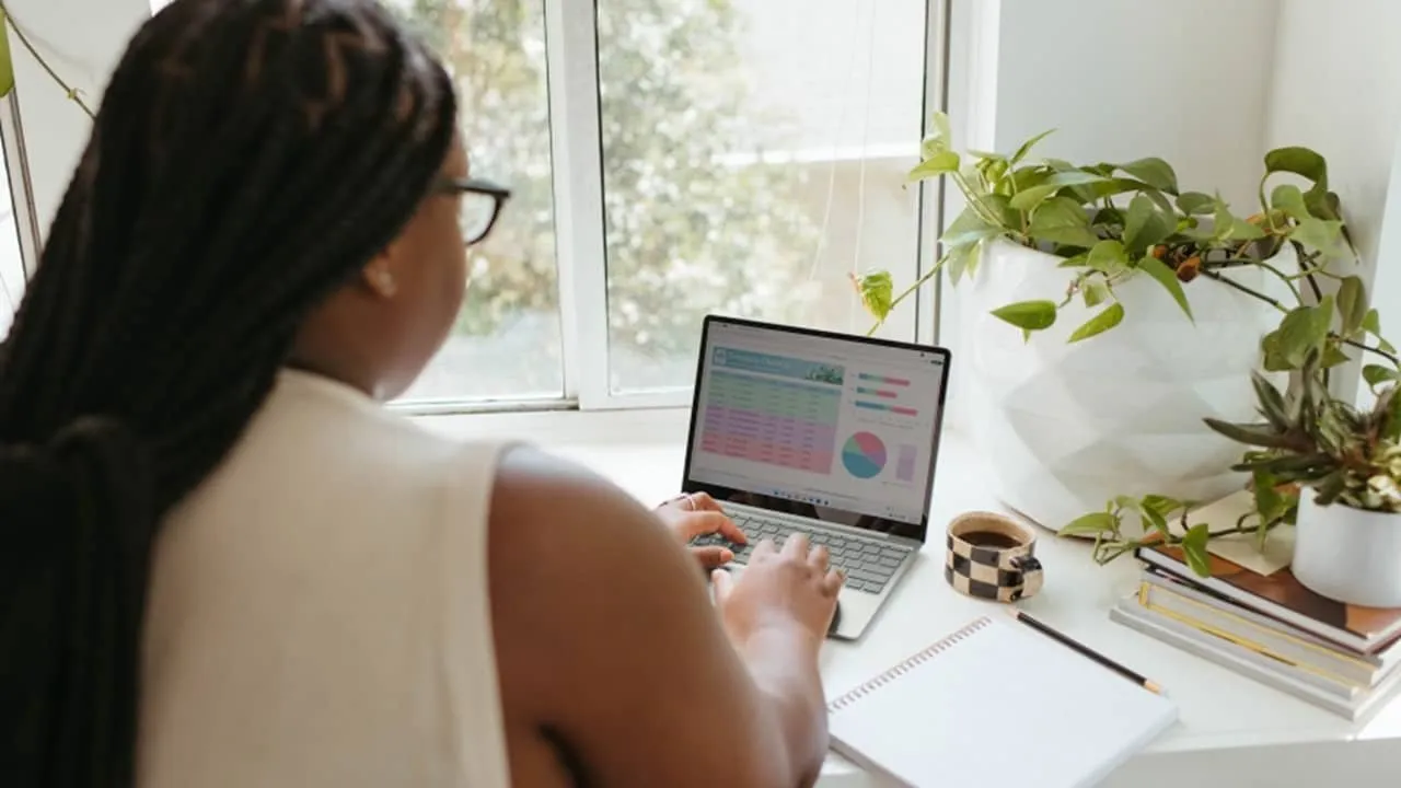 ノートパソコンで Excel を使用している女性。