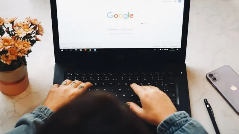 Person, die Google auf einem Laptop verwendet.