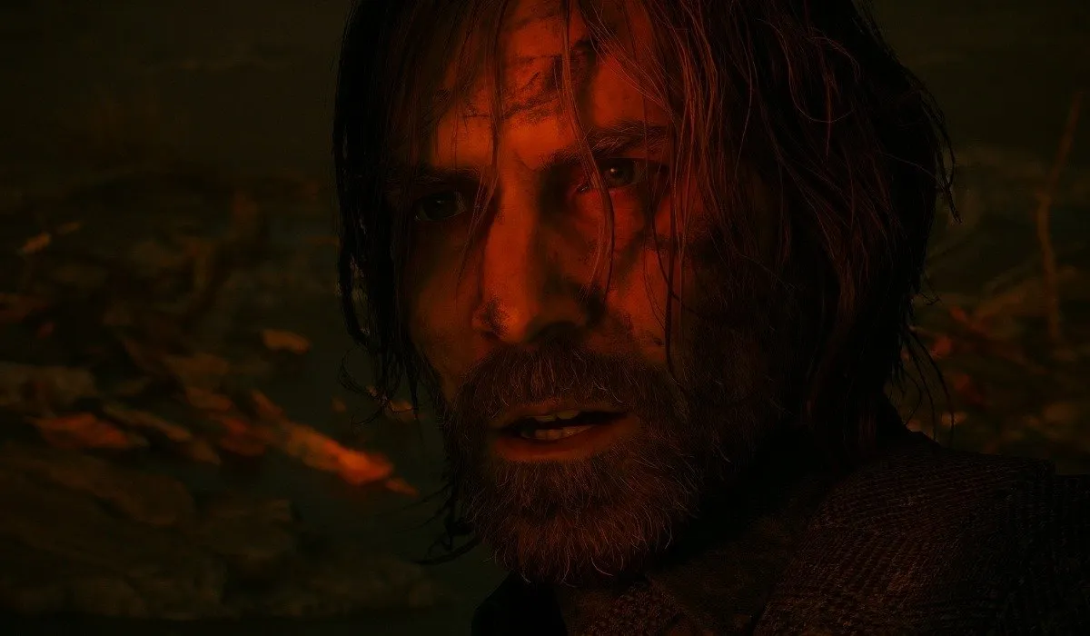 Screenshot van Alan Wake 2 waarin Alans gezicht baadt in rood licht