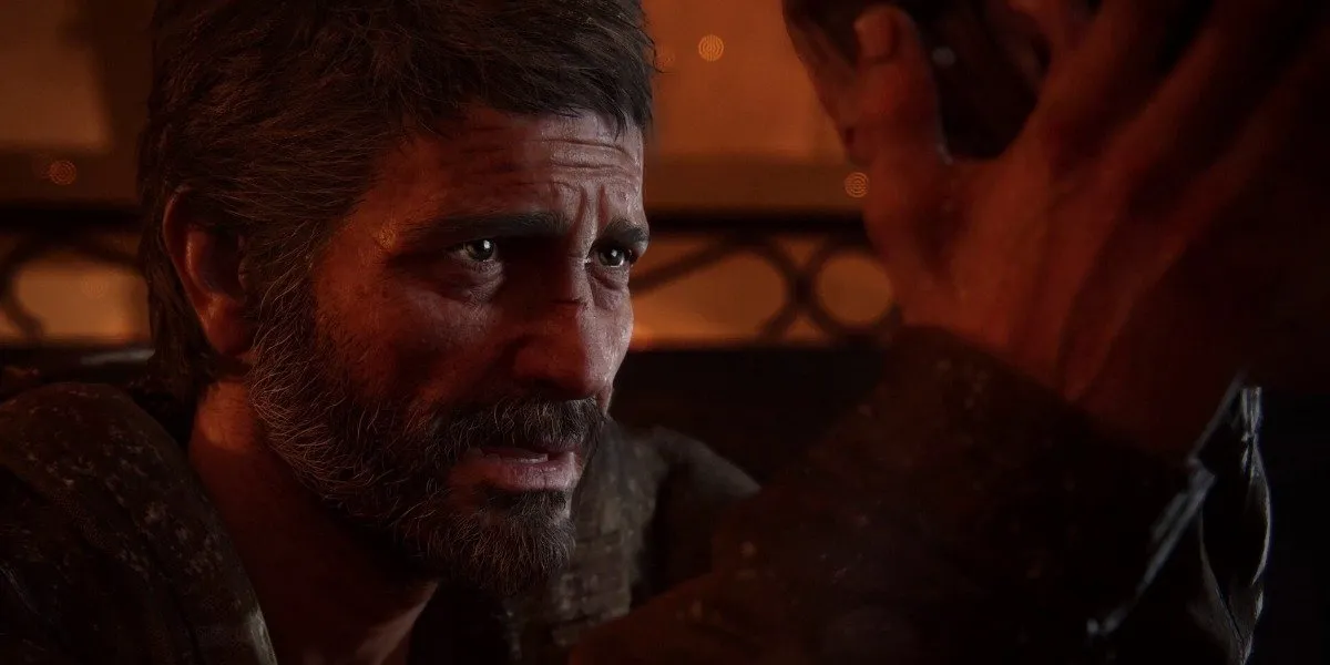 Screenshot aus The Last Of Us Part 1, der zeigt, wie Joel den Kopf einer Person streichelt