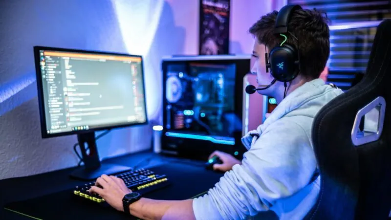 Una persona que usa auriculares y utiliza una PC para juegos.
