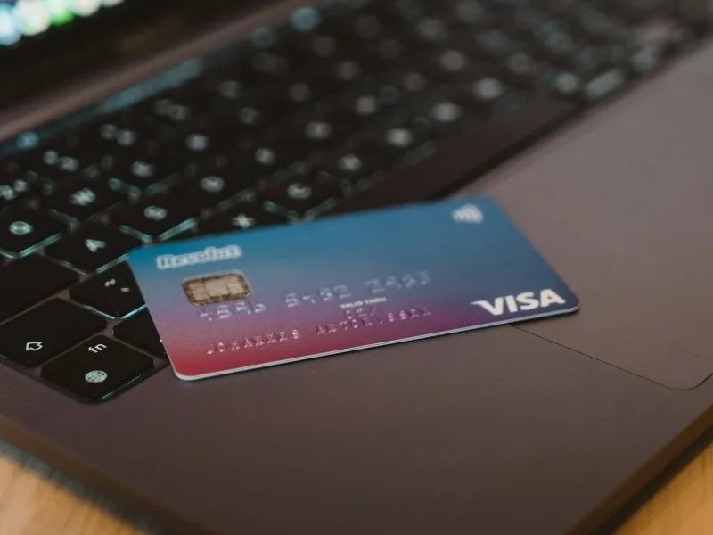 Una carta di credito appoggiata sulla tastiera di un computer portatile