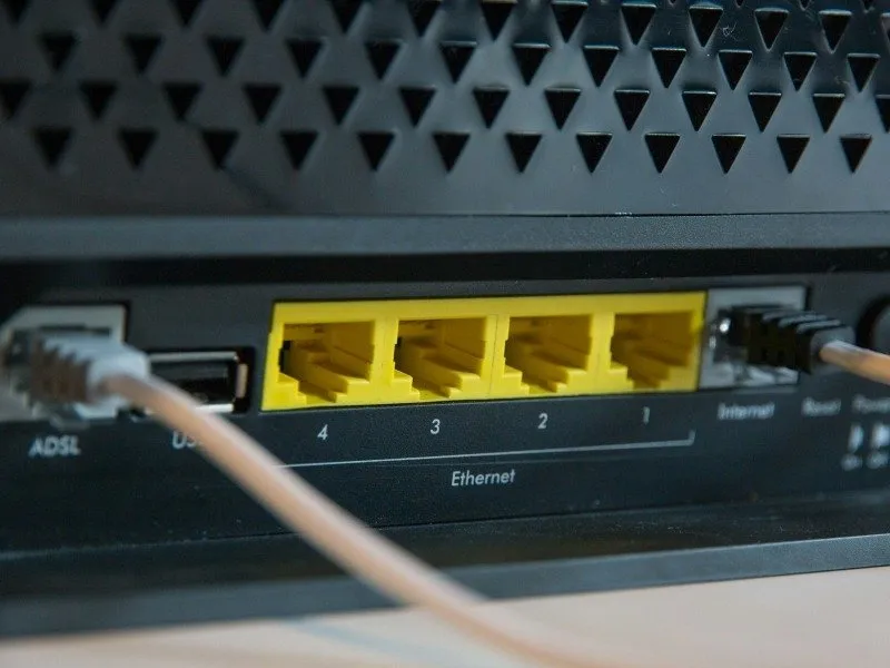 Un primo piano di un router wireless che mostra porte Ethernet e cavi