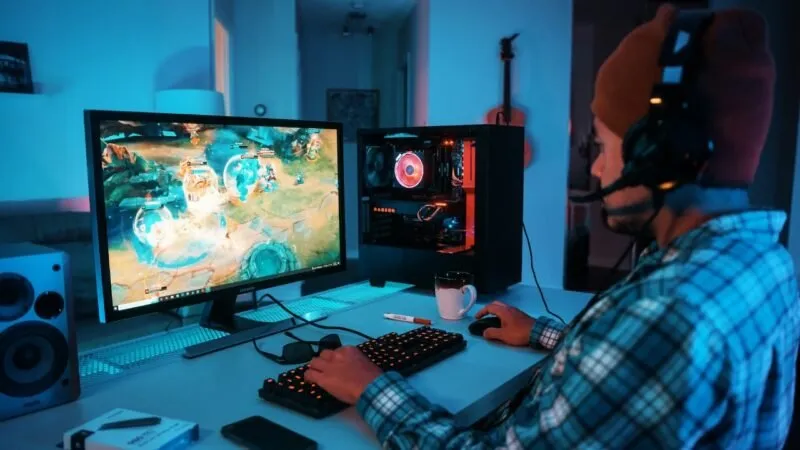 Mann mit Kopfhörern spielt ein Spiel auf einem Gaming-PC
