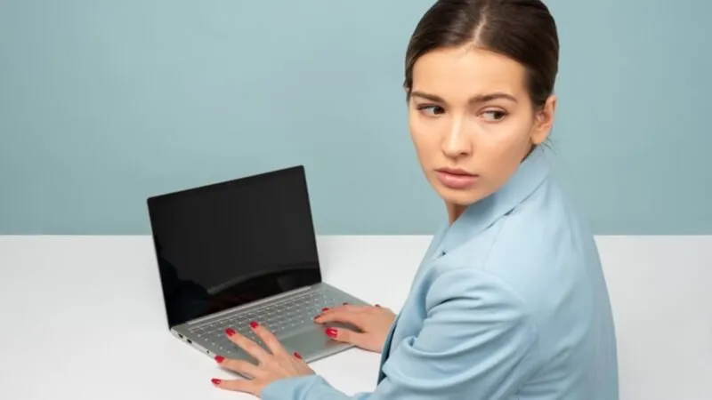 Een vrouw sluipt op een laptop.