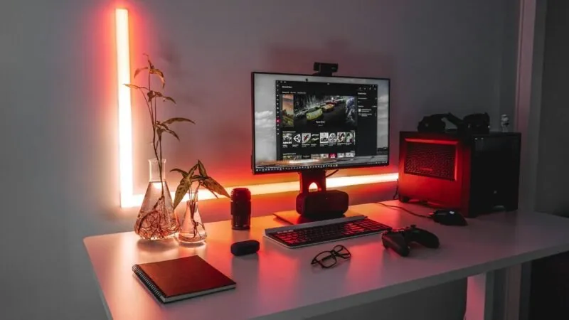 Een gaming-pc-opstelling op een bureau met een monitor, pc, toetsenbord, muis en gamepad