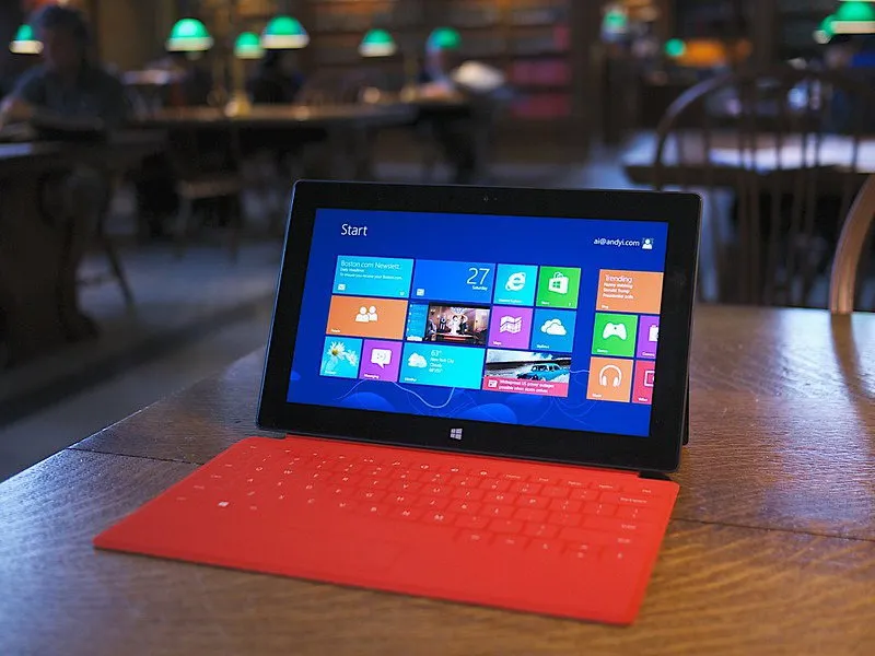 Computadora portátil Microsoft Surface RT sobre un escritorio marrón con el fondo borroso