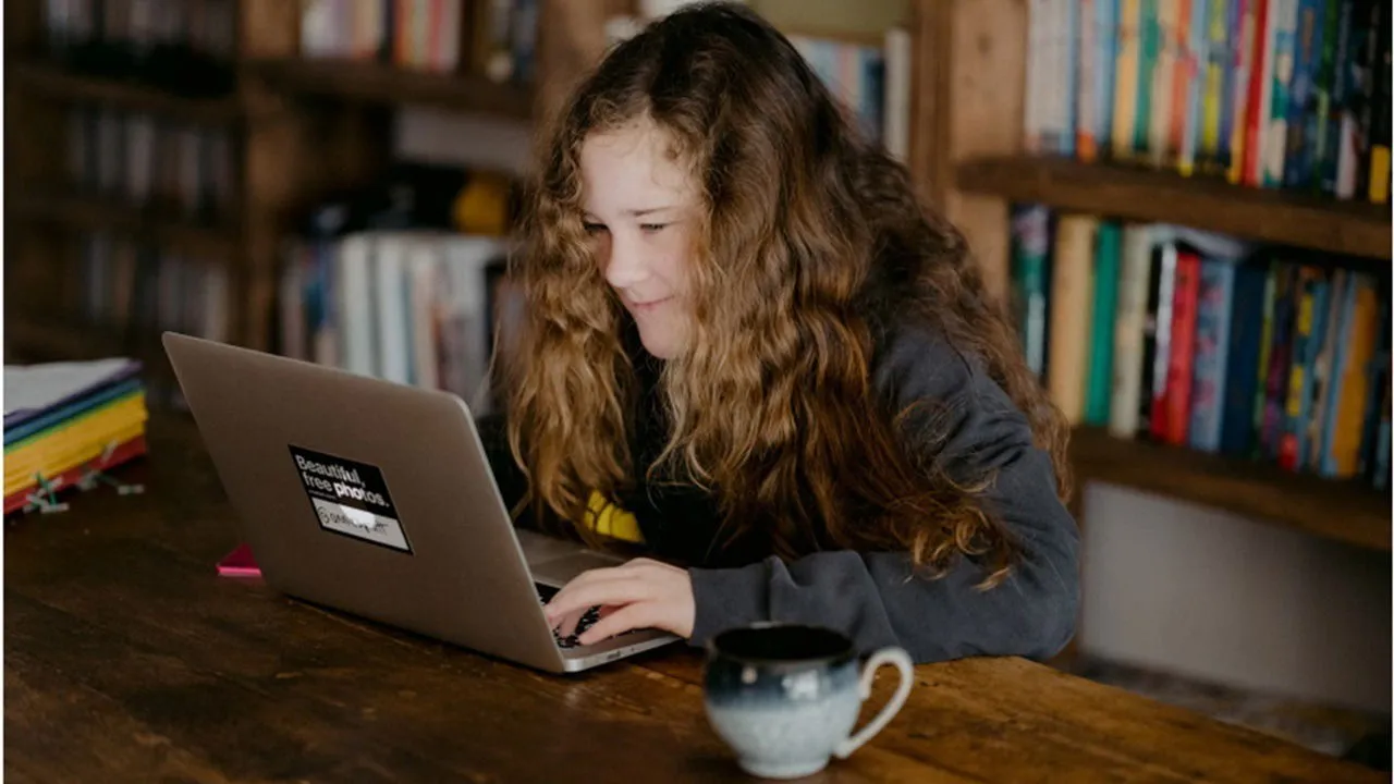 Een student gebruikt een computer in de bibliotheek.