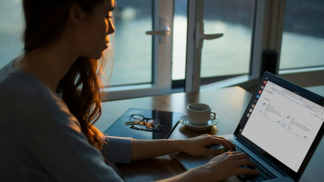 Een foto van een vrouw die haar laptop op een tafel gebruikt.