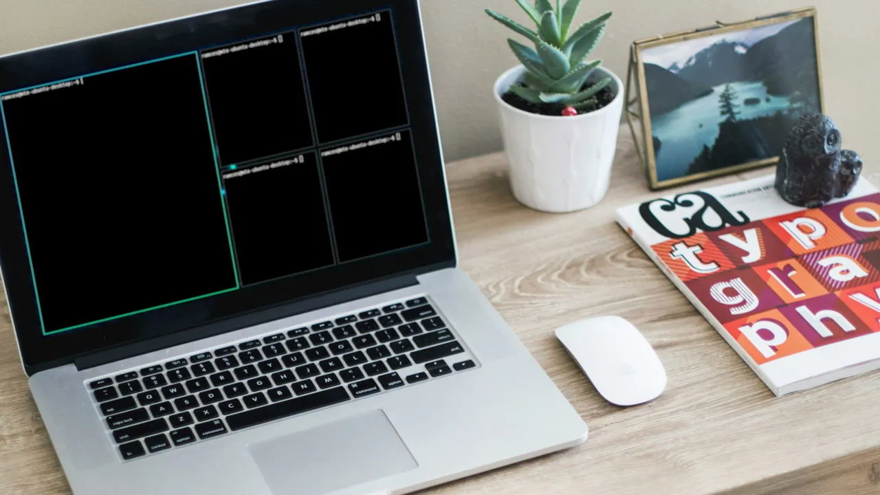 Une photographie d'un ordinateur portable posé sur un simple bureau.