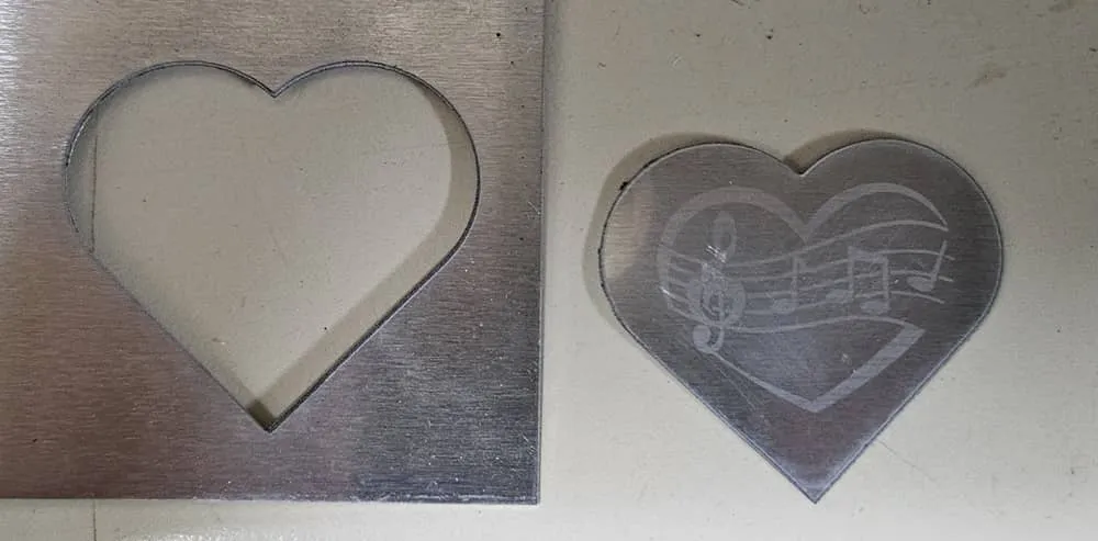 Un corazón de aluminio con grabado de notas musicales.