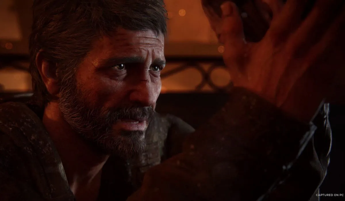 Un moment poignant du remake de The Last of Us Part I, où un homme exprime sa douleur tout en réconfortant une fille.